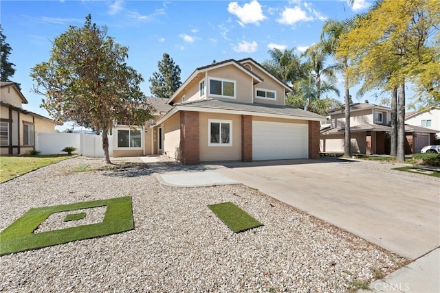 traditional-style house featuring a garage, driveway, and fence