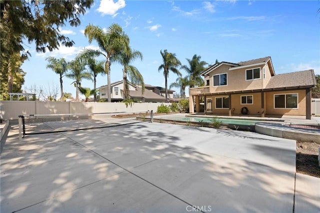 exterior space featuring a patio, a jacuzzi, a fenced in pool, and fence