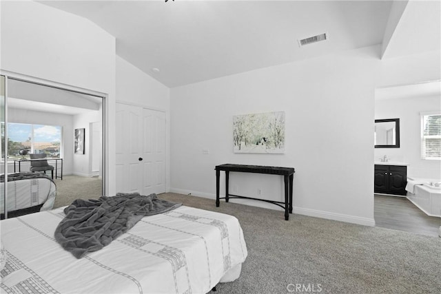 carpeted bedroom featuring multiple windows, visible vents, baseboards, and connected bathroom