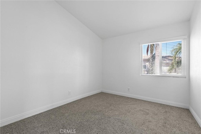 carpeted empty room with lofted ceiling and baseboards