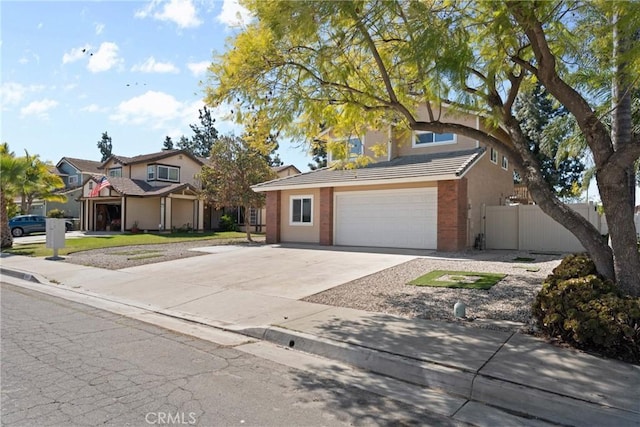 traditional home with a garage, a tile roof, driveway, and fence