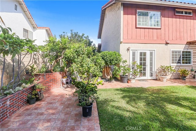 back of property with a patio, a lawn, fence, and stucco siding