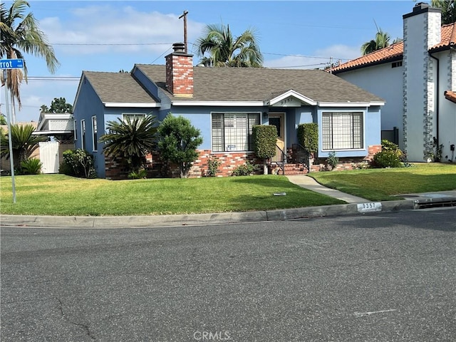 view of front of house featuring a front yard, stucco siding, fence, and a chimney