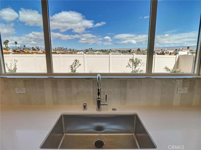 room details featuring tasteful backsplash, light countertops, and a sink