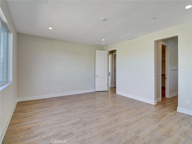 empty room featuring recessed lighting, baseboards, and light wood-style flooring