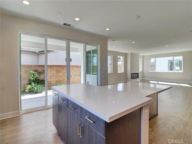 kitchen featuring light wood finished floors, visible vents, a kitchen island, and modern cabinets