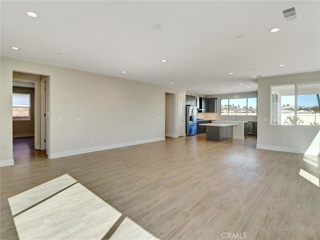 unfurnished living room featuring visible vents, recessed lighting, and light wood-style floors