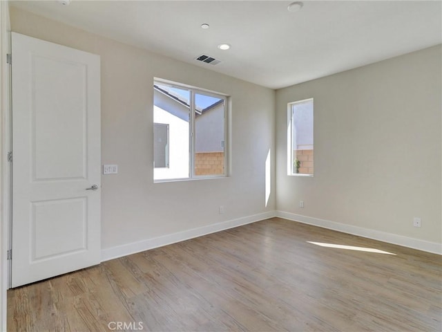 empty room with recessed lighting, visible vents, baseboards, and wood finished floors