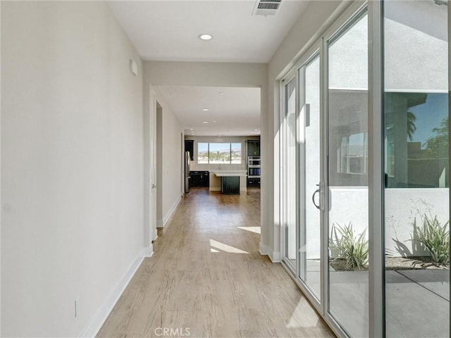 hall with recessed lighting, baseboards, visible vents, and light wood-type flooring