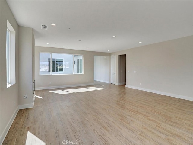 unfurnished room with light wood finished floors, visible vents, recessed lighting, and baseboards