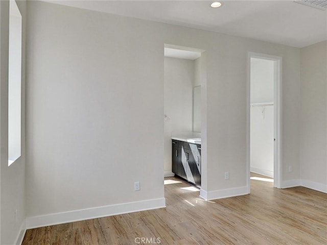 unfurnished living room featuring recessed lighting, light wood-style flooring, visible vents, and baseboards