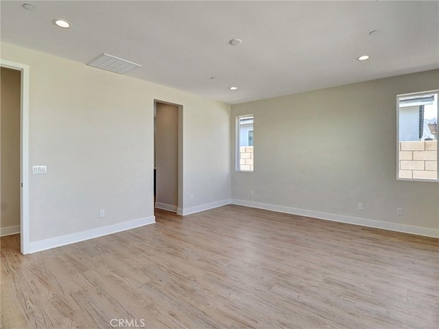 empty room featuring visible vents, recessed lighting, light wood-type flooring, and baseboards