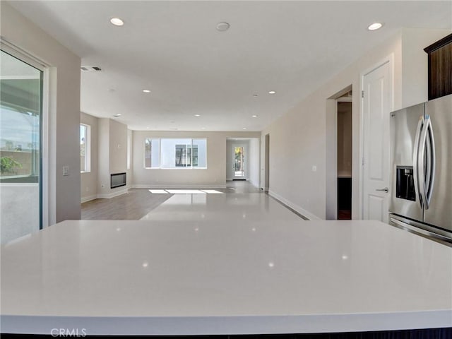 kitchen with visible vents, a spacious island, open floor plan, recessed lighting, and stainless steel fridge with ice dispenser