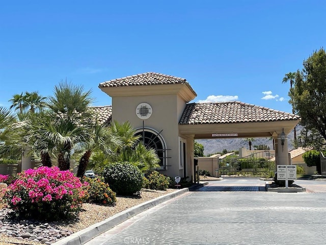 view of road with a gate, curbs, and a gated entry