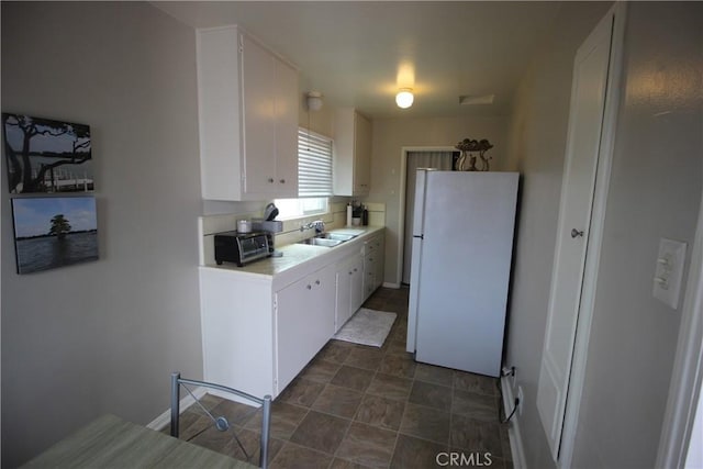 508 30th St, Hermosa Beach, CA 90254 - kitchen with freestanding refrigerator, light countertops, white cabinetry, and stone finish floors