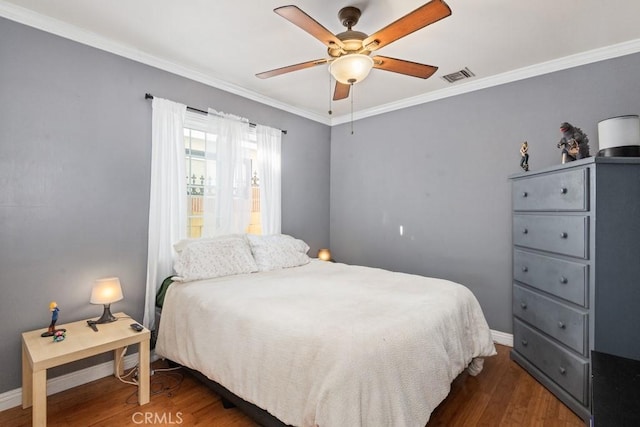 bedroom featuring crown molding, wood finished floors, visible vents, and baseboards