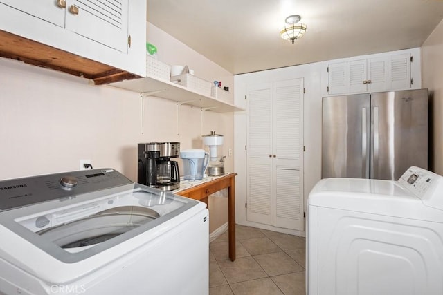 clothes washing area with light tile patterned floors and washing machine and dryer