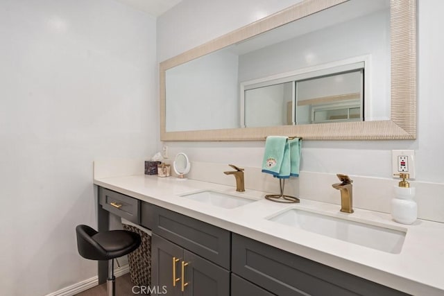 bathroom with a sink, baseboards, and double vanity