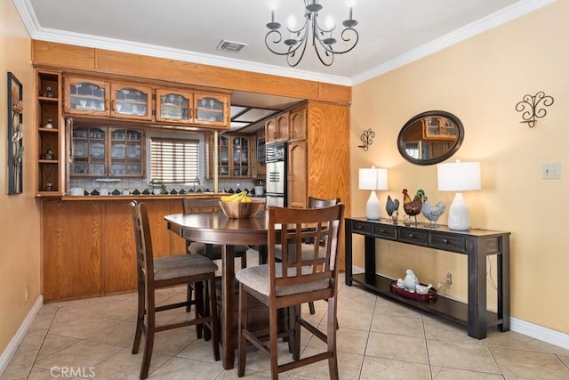 dining room with crown molding, light tile patterned flooring, visible vents, and a chandelier