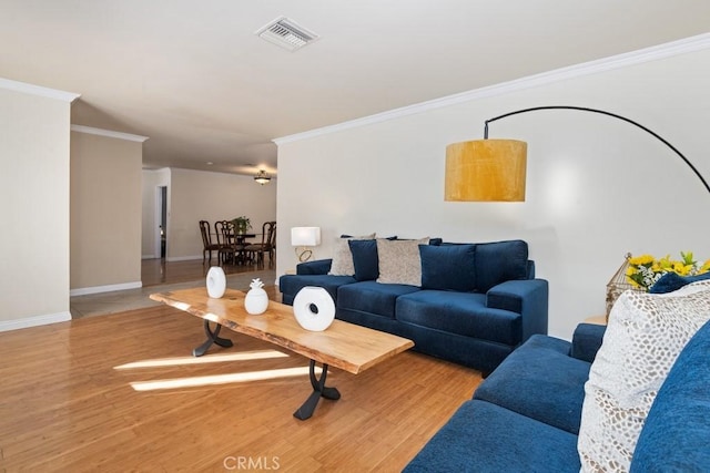 living area featuring ornamental molding, wood finished floors, visible vents, and baseboards