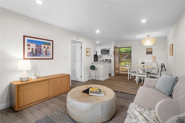 living room featuring recessed lighting, baseboards, and wood finished floors