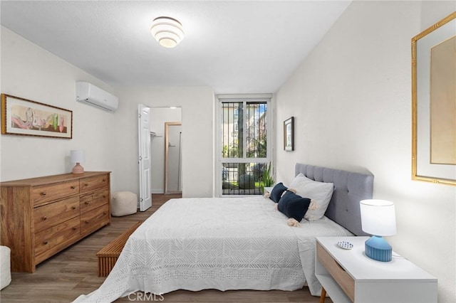 bedroom with wood finished floors and a wall mounted air conditioner