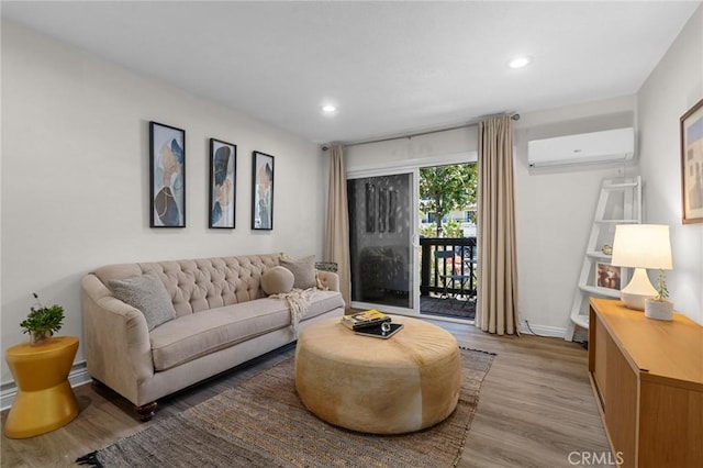 living area with recessed lighting, baseboards, light wood finished floors, and a wall mounted AC