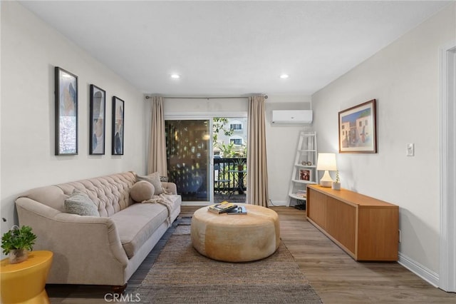 living room featuring a wall mounted air conditioner, baseboards, light wood-style flooring, and recessed lighting