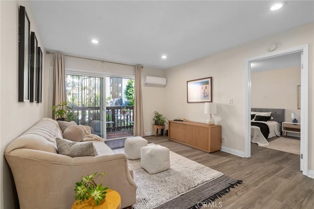 living area featuring light wood-type flooring, baseboards, an AC wall unit, and recessed lighting