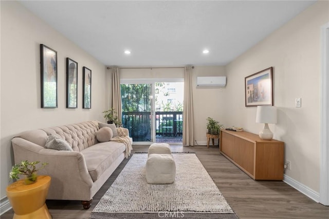 living area with baseboards, wood finished floors, an AC wall unit, and recessed lighting