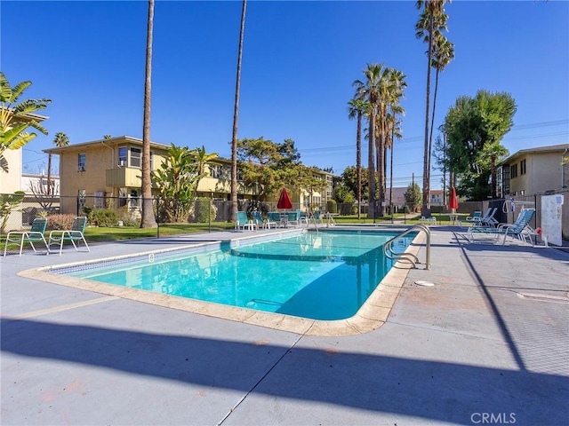 pool with a patio and fence