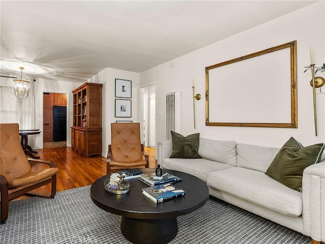 living area with an inviting chandelier and wood finished floors