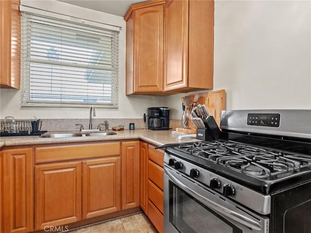 kitchen with a sink, stainless steel range with gas cooktop, and light countertops