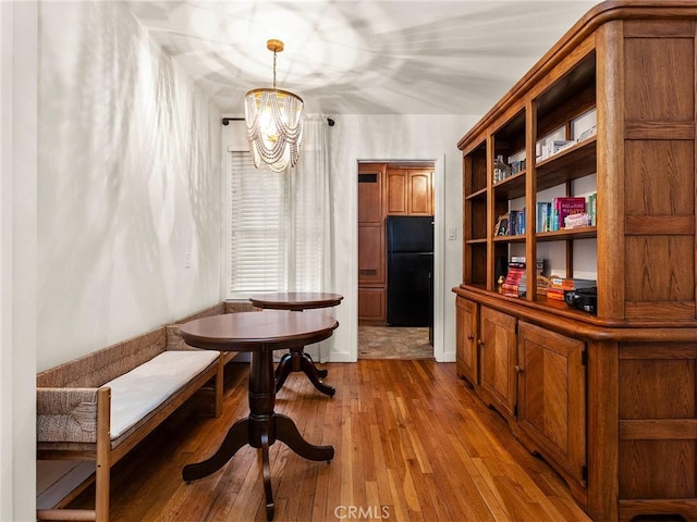 dining space featuring an inviting chandelier, wood-type flooring, and breakfast area