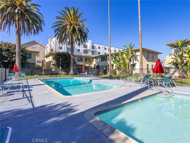 community pool featuring a patio and fence