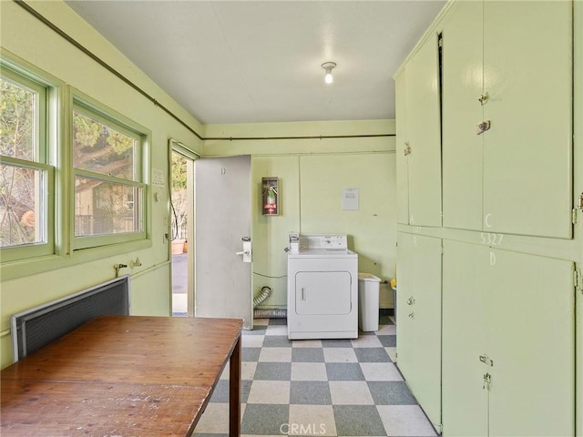 clothes washing area featuring cabinet space, light floors, radiator, and washer / clothes dryer