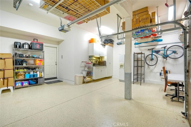 garage featuring a garage door opener and baseboards