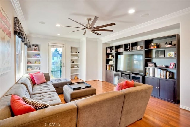 living area featuring crown molding, built in features, light wood-style floors, and recessed lighting