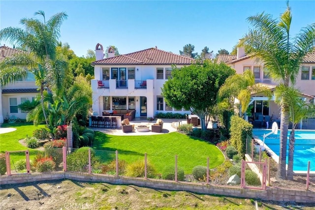 back of property with a balcony, fence private yard, a lawn, and outdoor dry bar