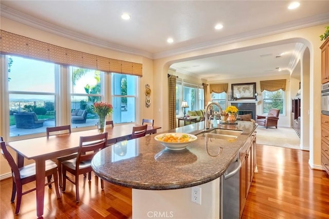 kitchen with a sink, open floor plan, a fireplace, and crown molding