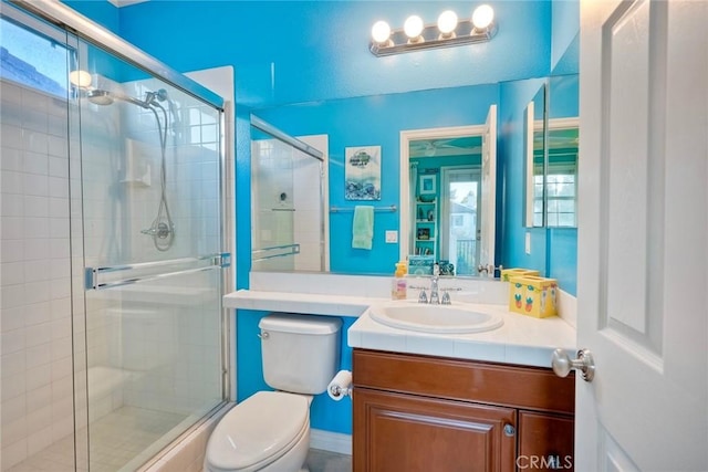 full bathroom featuring vanity, toilet, and a shower stall