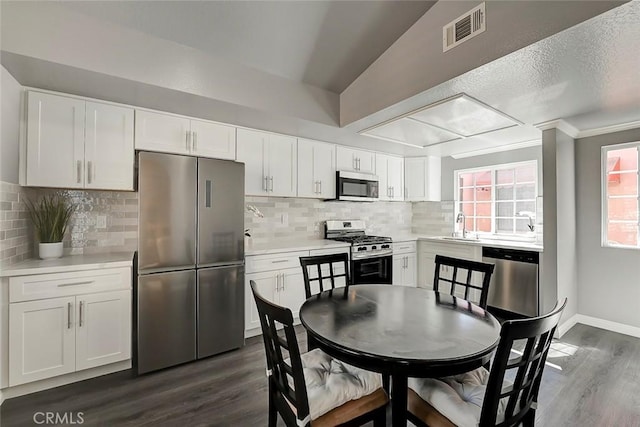 kitchen with visible vents, light countertops, appliances with stainless steel finishes, dark wood-style floors, and a sink