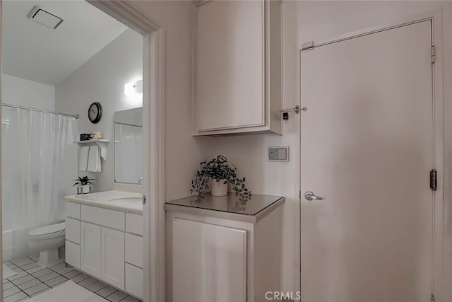 full bath with tile patterned floors, toilet, vanity, and shower / bath combo