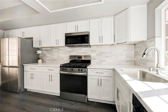 kitchen with white cabinetry, backsplash, appliances with stainless steel finishes, and a sink