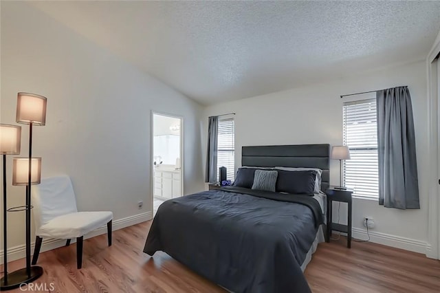 bedroom featuring vaulted ceiling, multiple windows, and wood finished floors