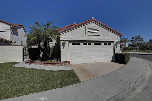 mediterranean / spanish-style home with a tile roof, a front yard, stucco siding, driveway, and an attached garage