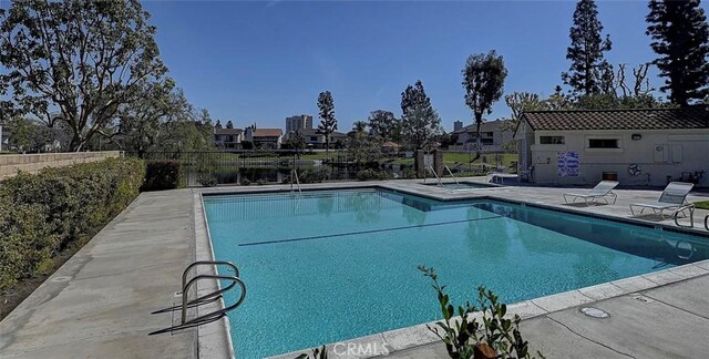 pool with a patio and fence