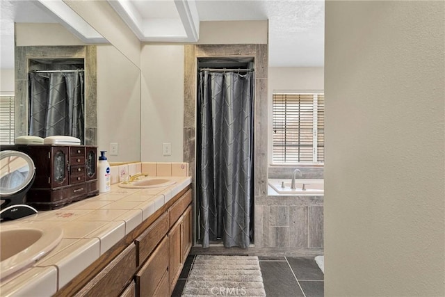 full bathroom with a bath, a tile shower, double vanity, and a sink