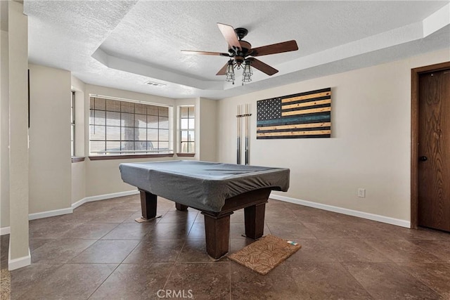 rec room with baseboards, a raised ceiling, and a textured ceiling