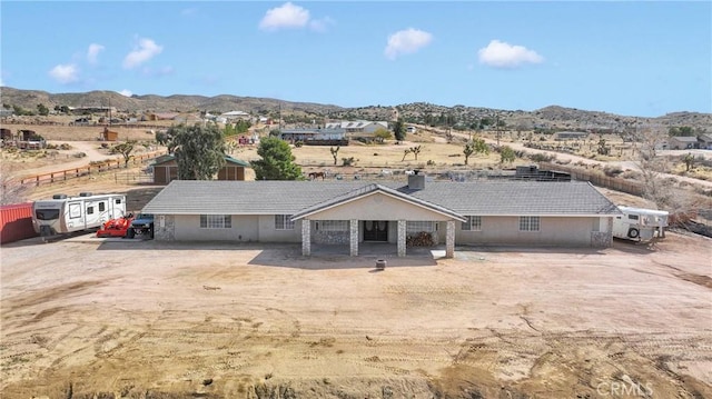 view of front of property featuring a mountain view, a patio area, stucco siding, and a tile roof